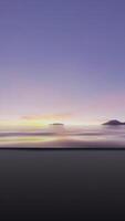 The sun is setting over the water with mountains in the background video