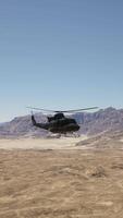 A helicopter flying over a desert landscape with mountains in the background video