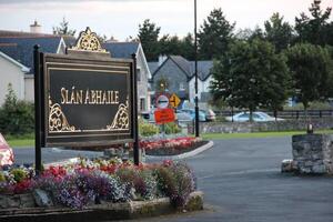 Irish Welcome Sign in Front of Homes and Trees photo
