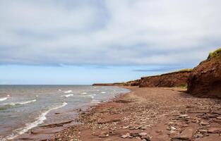 Red Sand Beach and Cliffs on a Cloudy Day in Prince Edward Island photo