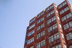 Modern Red Brick Building With Windows Against a Clear Blue Sky, in Spain photo