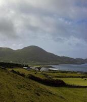 A Green Hillside Overlooking the Irish Coast on a Cloudy Day photo