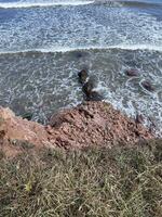 Red Cliffs Overlooking Atlantic Ocean Waves on the Magdalen Islands, Quebec, Canada photo