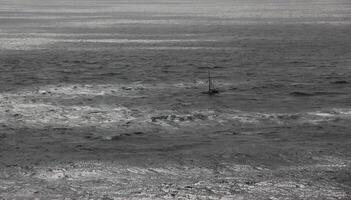 Distant Sailboat On A Gray Day In The Ocean in Ireland photo