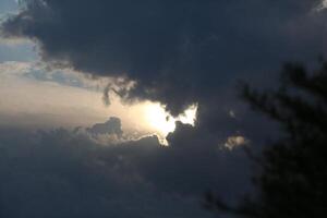 Sunset Through Clouds Over A Mountain Range photo
