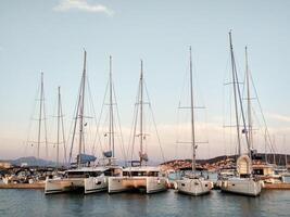 Sailing yachts stand in a row in the marina at sunset photo