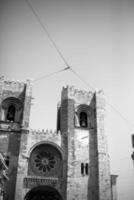 Lisbon iconic Se Cathedral, a stunning blend of Romanesque and Gothic architecture, stands majestically, with its twin towers and rose window as focal points. photo