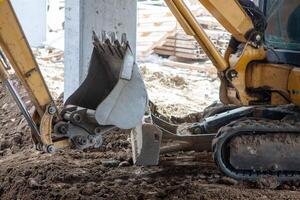 Close-up view of an excavator claw scoop digging into earth, capturing the power and precision of heavy machinery in action. photo