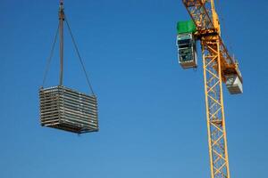 A construction crane hoists materials across a busy worksite, showcasing the dynamic energy and precision involved in modern building projects. photo