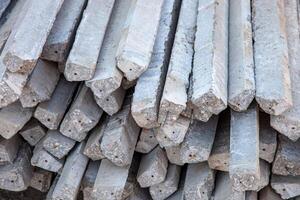 A stack of concrete beams ready for use in construction, showcasing their strength and durability. Ideal for illustrating modern building materials in civil engineering projects. photo