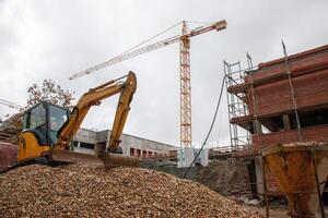 Construction site featuring a crane and a backhoe, undergoing renovation. Dynamic scene of urban development in progress. photo