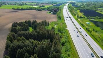 Drone view of a highway in Germany with a lot of traffic and many green fields around it. photo