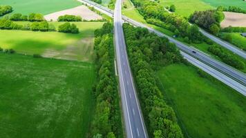 Drone view of a highway in Germany with a lot of traffic and many green fields around it. photo