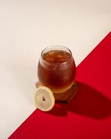 ced lemon tea is a tea drink served cold with ice cubes and lemon. photo