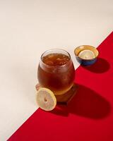 ced lemon tea is a tea drink served cold with ice cubes and lemon. photo