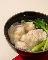 Wontons or dumplings are a soup dish containing pieces of meat and vegetables originating from China photo