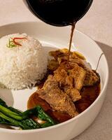 Beefsteak is processed beef that goes through a grilling process until the meat is cooked inside and out, served with warm sauce and rice photo