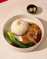 Beefsteak is processed beef that goes through a grilling process until the meat is cooked inside and out, served with warm sauce and rice photo