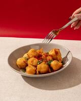 Salted chili tofu is a typical Indonesian food made from tofu which is fried and then given spicy chili seasoning photo