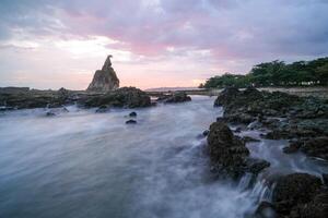 seascape is very beautiful with coral rocks and sea water that looks very soft like cotton at Sawarna Beach, Indonesia. slow shutter speed effect photo