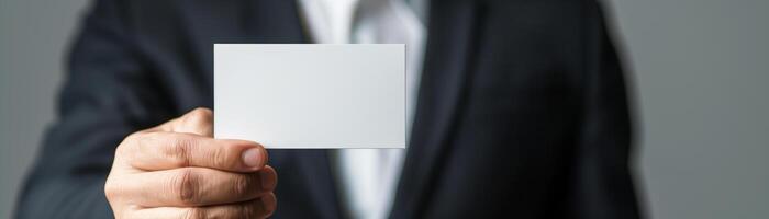 Businessman in suit holding blank business card, ready for customization. Perfect for corporate identity, business networking concepts. photo