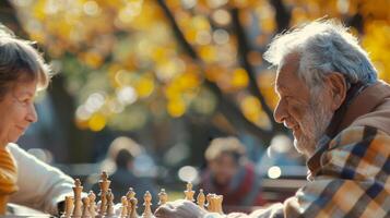 Elderly couple playing chess in a park during autumn, enjoying a sunny day filled with relaxation and strategy. photo