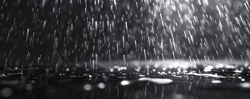 A black background with rain, raindrops falling. photo