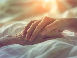 Two hands touching, symbolizing care and compassion in a hospital or hospice setting bathed in warm light. photo