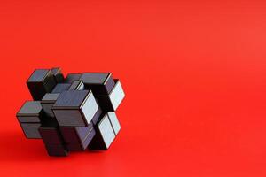 Closeup of geometric shape puzzle over red background with negative space. Science and technology concept photo