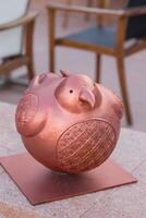 Abstract copper bird sculpture with etched patterns displayed prominently on urban steps. photo