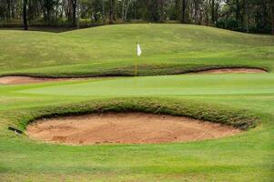 Scenery view of bunker in golf course. A bunker is positioned in the golf hole to guard the desired position in the landing area or green. photo