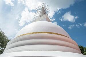 The large white stupa in Sri Maha Bodhi Viharaya temple in Kandy city, Sri Lanka. Stupa is a ceremonial burial mound used for the veneration of Buddhist saints and relics. photo