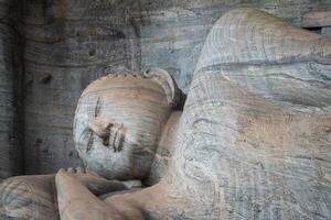 Beautiful reclining Buddha is 14 m long, picturing Buddha entering Nirvana at Gal Vihara in ancient city of Polonnaruwa, Sri Lanka. photo