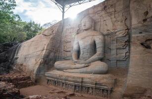 Beautiful sitting Buddha at Gal Vihara. This is an unusual feature in ancient Sinhalese sculpture in ancient city of Polonnaruwa. Gal Vihara is a group of four beautiful Buddhas carved by granite. photo