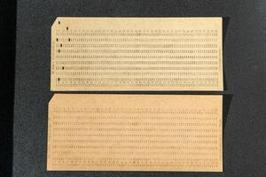 Punch card is a storage medium. Perforated cardboard, paper with holes to automate information, was used in the first old computers photo