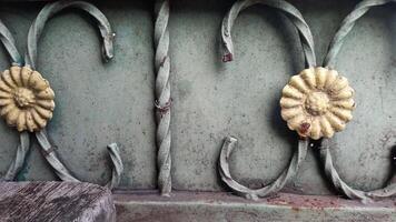 a close up of a metal fence with decorative flowers photo