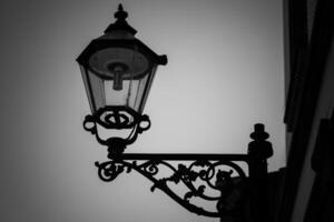 lamp post with a light on it is silhouetted against a cloudy sky photo