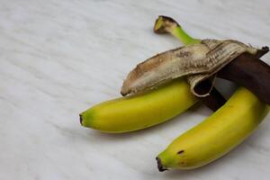 Dirty banana in open peel spoiled banana fruit on table photo