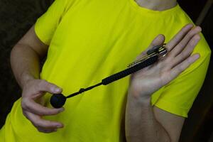 Convenient keychain made of paracord hangs on keys for self-defense, metal ball acting as baton is covered with laces photo