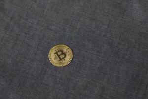 Bitcoin on blue fabric background, physical version of the main gold cryptocurrency, concept of investing and saving money in electronic money photo