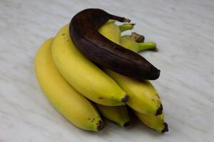 Bunch of bananas with one rotten banana photo