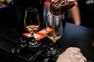 Bartender pours whiskey for tasting. photo