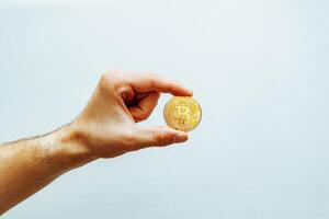 Bitcoin in hand on a light background. photo