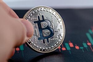 Close-up photo of crypto coin in hands. Bitcoin economy.