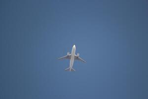 a large airplane flying through a clear blue sky photo