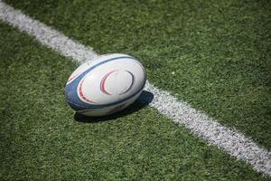 Rugby ball on lush green field, ready for action. Dynamic composition captures the essence of the game. photo