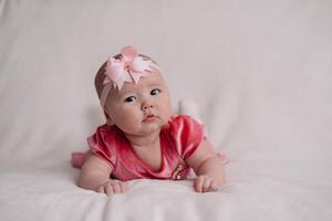 a child under one year old, lying on a white background photo