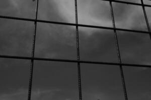 Black and white iron fence with rectangular weave. Monochrome of exterior on public park. Graphic Resources. Monochrome Background Photography. Light Shadow Photography Concept. photo