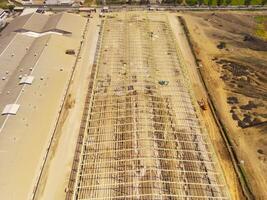Factory under construction. Aerial drone photo of a factory being built by workers on the edge of Bandung City. Top view of Factory construction