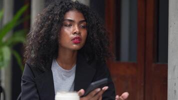 A black woman is getting ready for work in an office uniform in a public downtown area, carrying all her work equipment including a computer and a phone. video